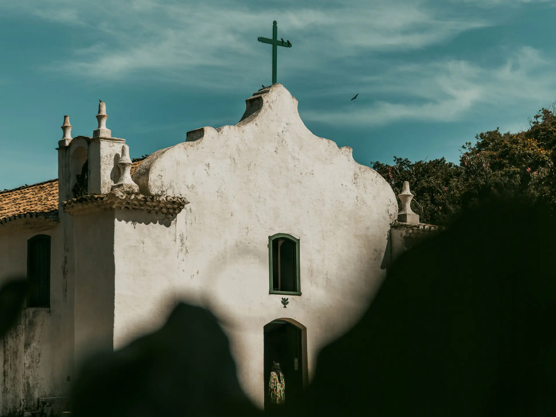 Fachada branca da Igreja de São João Batista no Quadrado de Trancoso, com cruz no topo