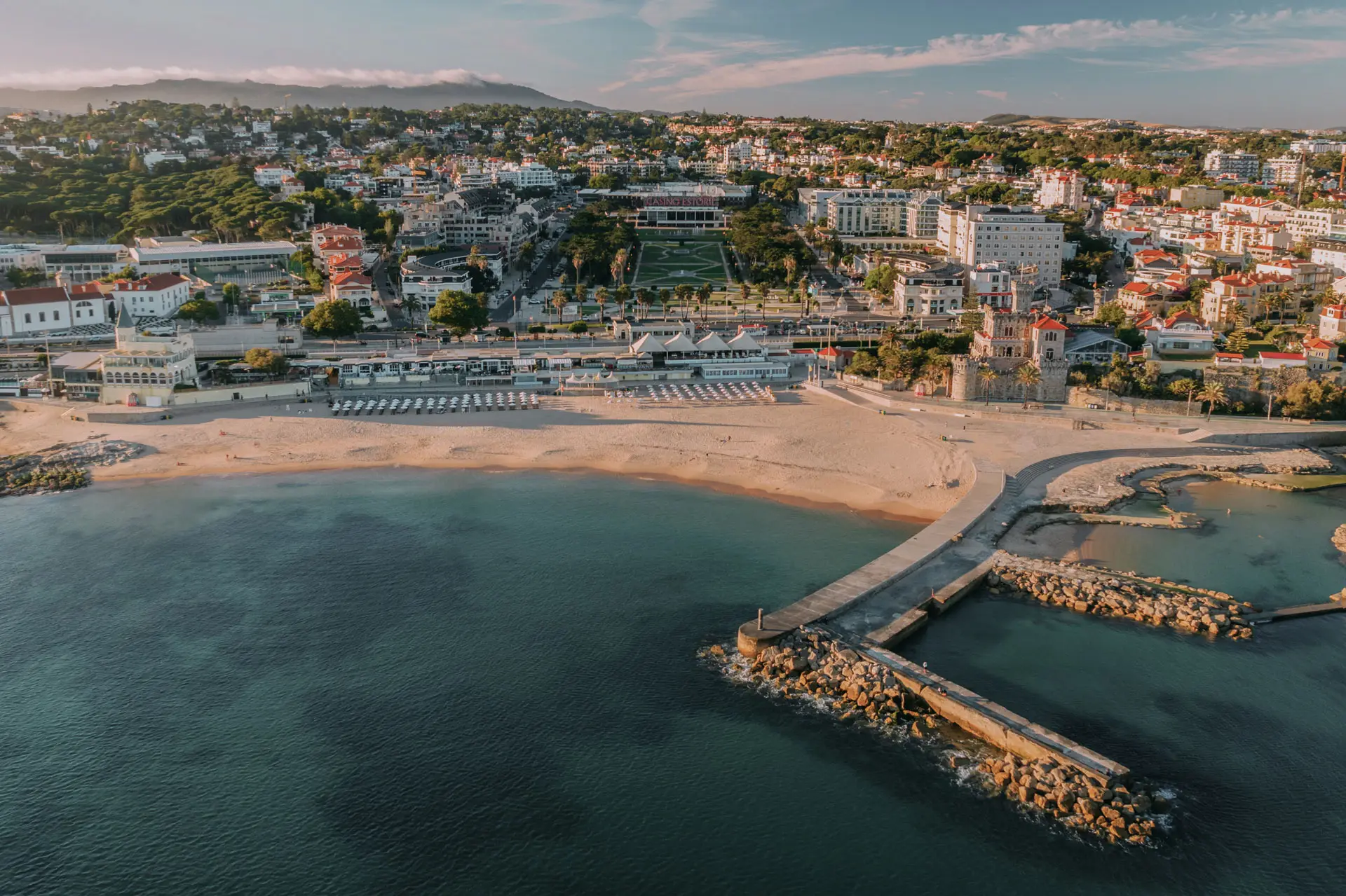 Vista aérea da orla do Estoril com praia, píer e casario