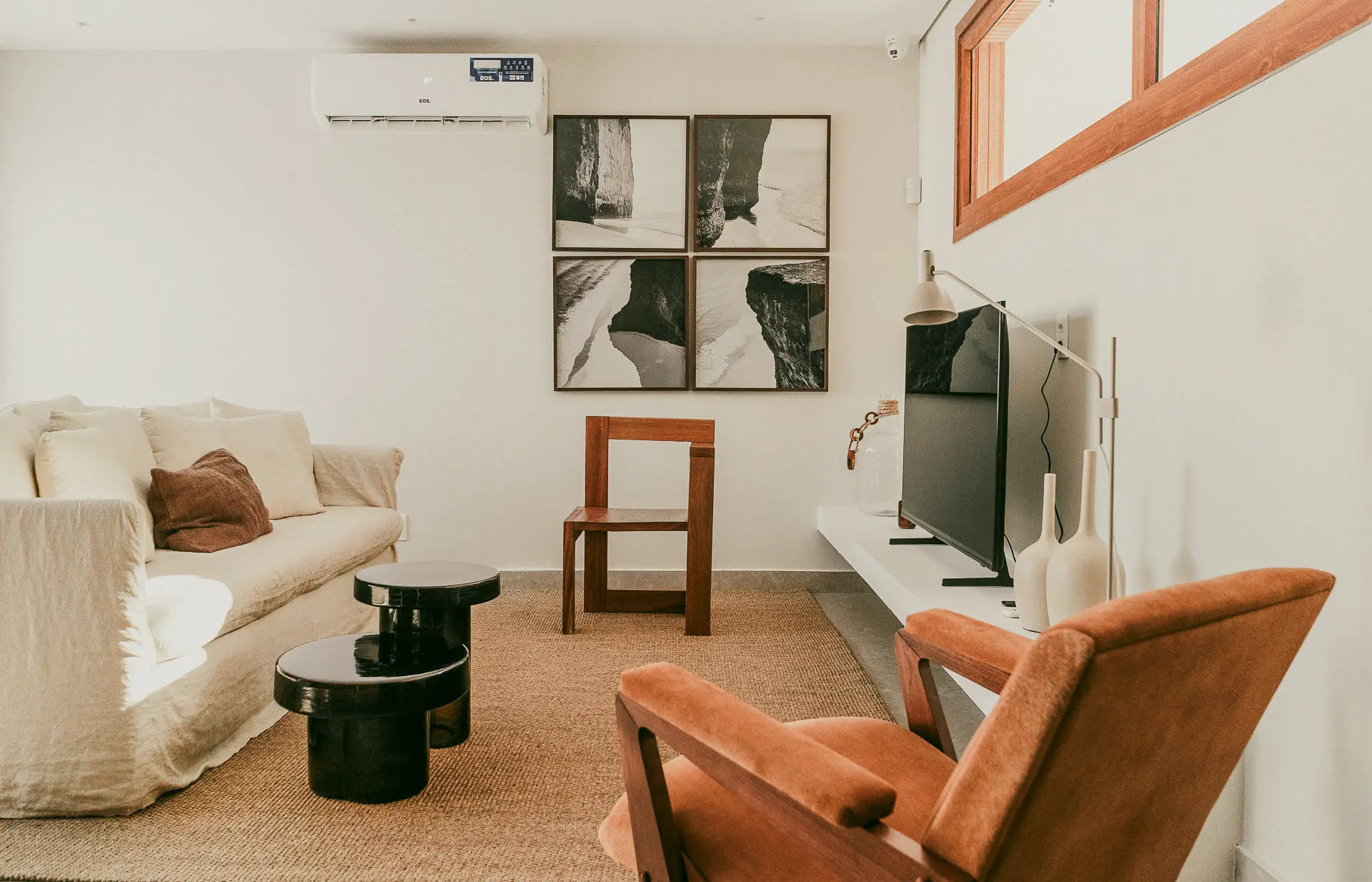 Show home living room with a linen sofa, framed prints and a TV