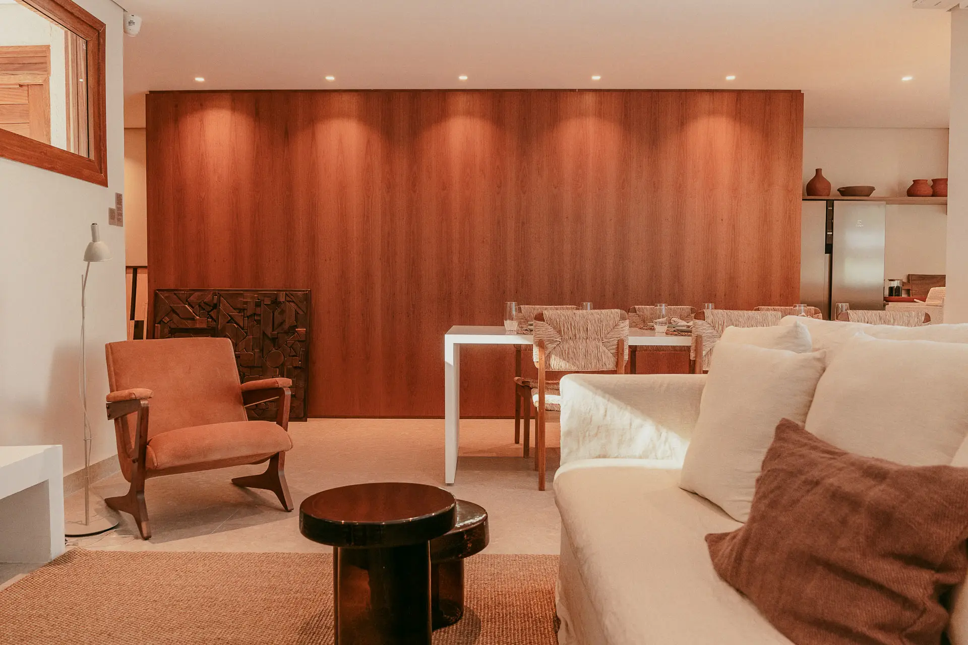 Show home living room with a wood-panelled wall, velvet armchair and light sofa