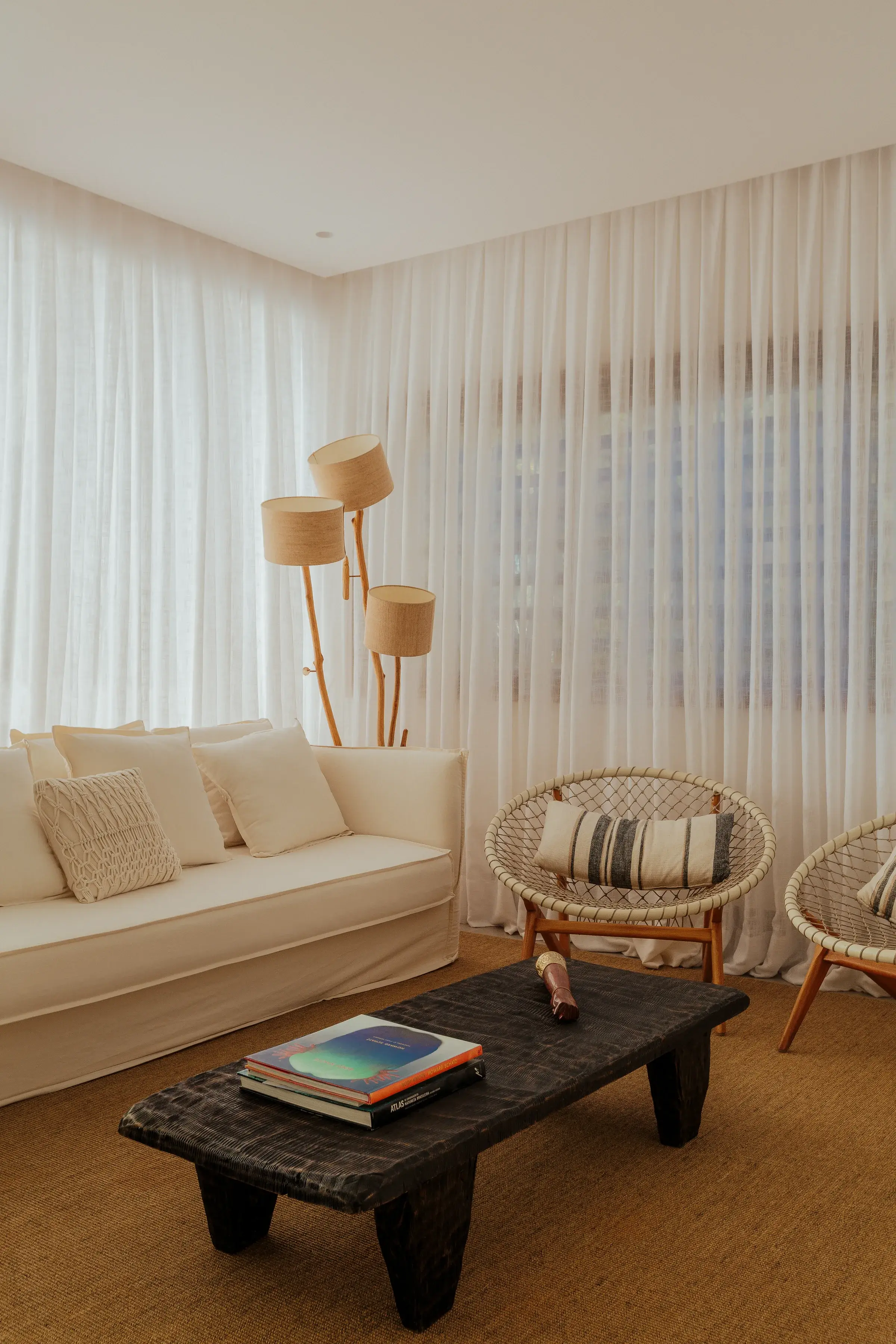 Light-filled Falésia living room with a sofa, fibre armchairs and a dark coffee table