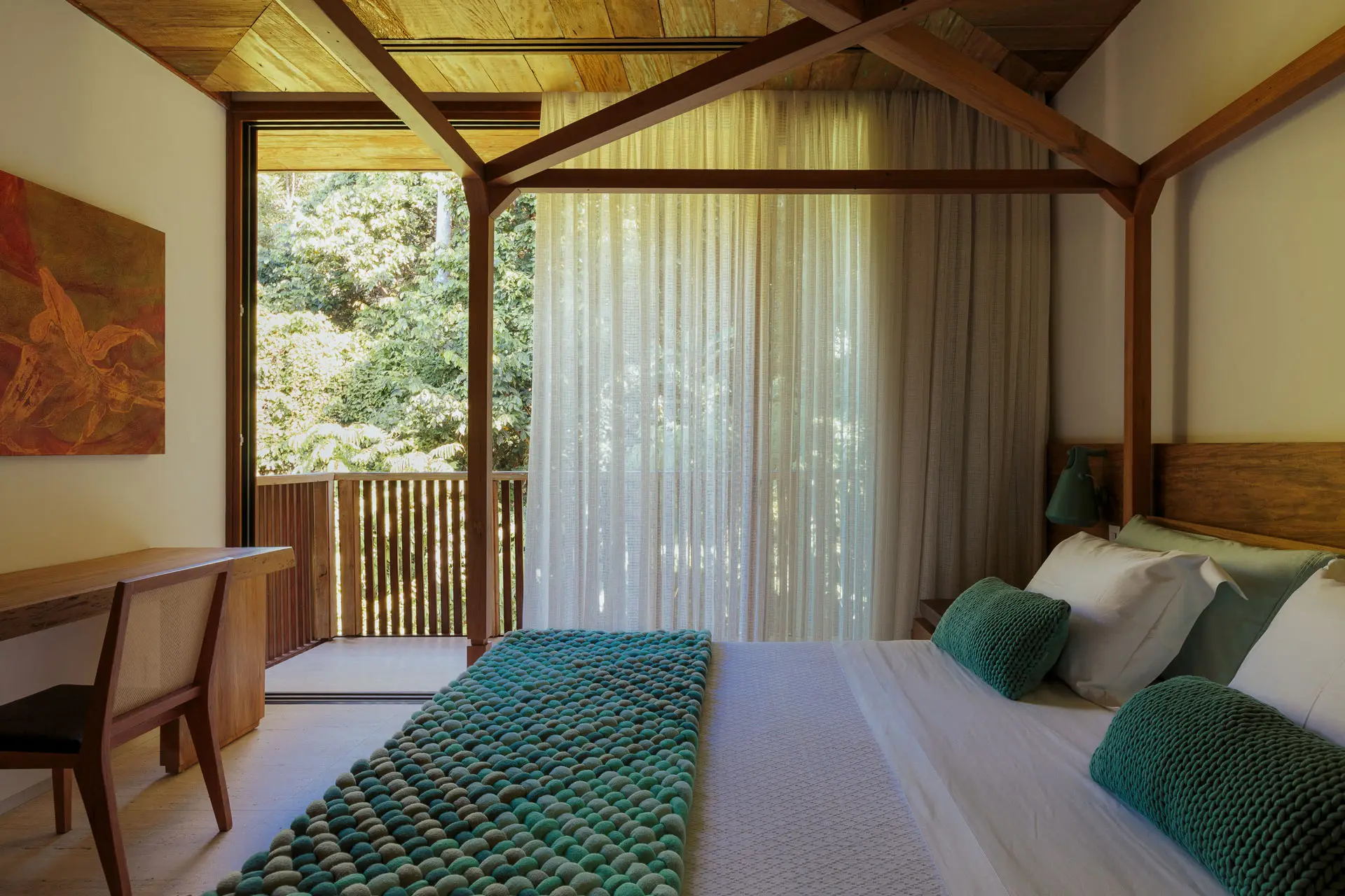 Falésia suite with a wooden headboard and a view of the forest