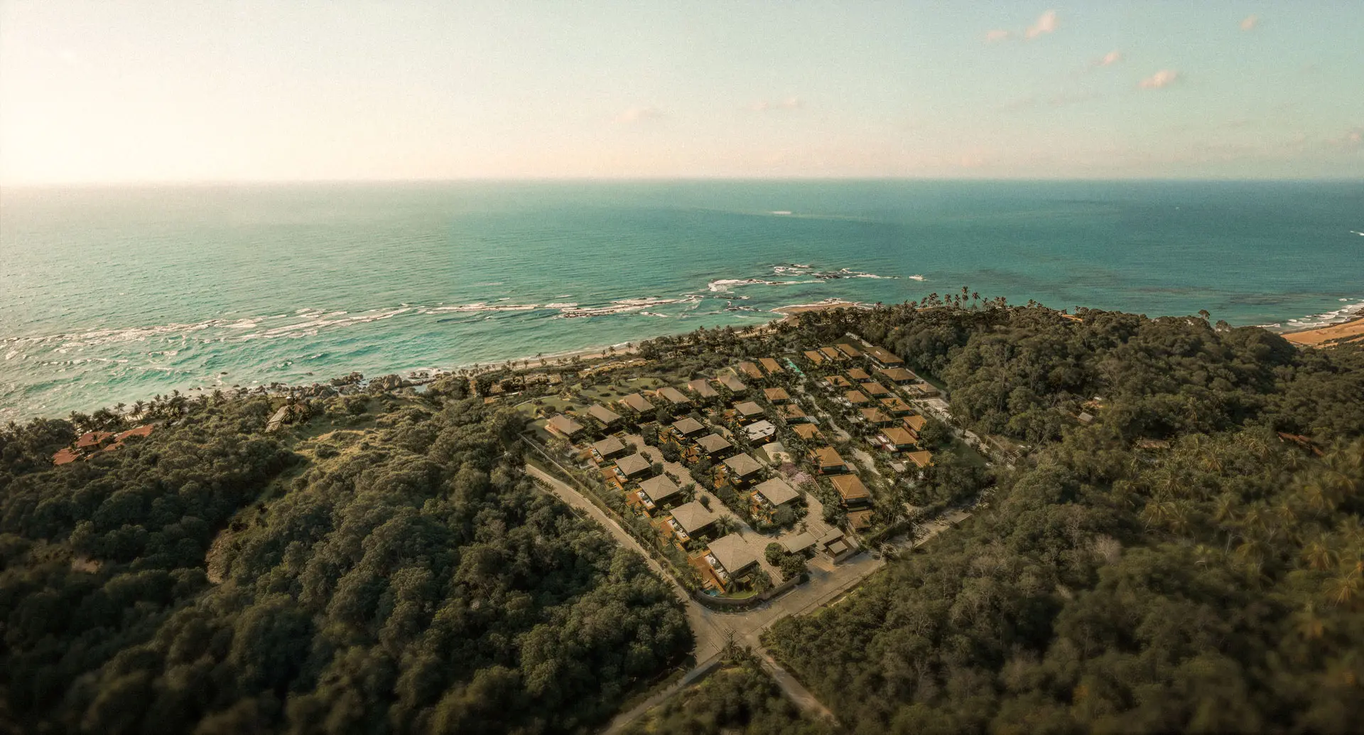 Aerial view of Azul: houses in the forest with the sea behind