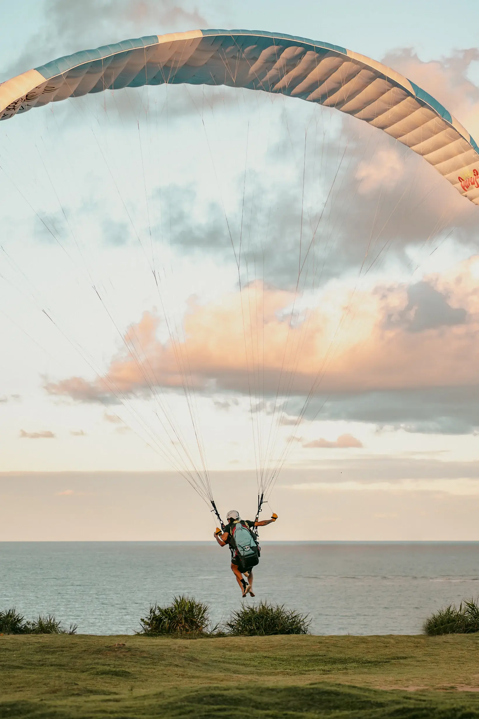 Parapente decolando do gramado na falésia de Pitinga, mar ao fundo