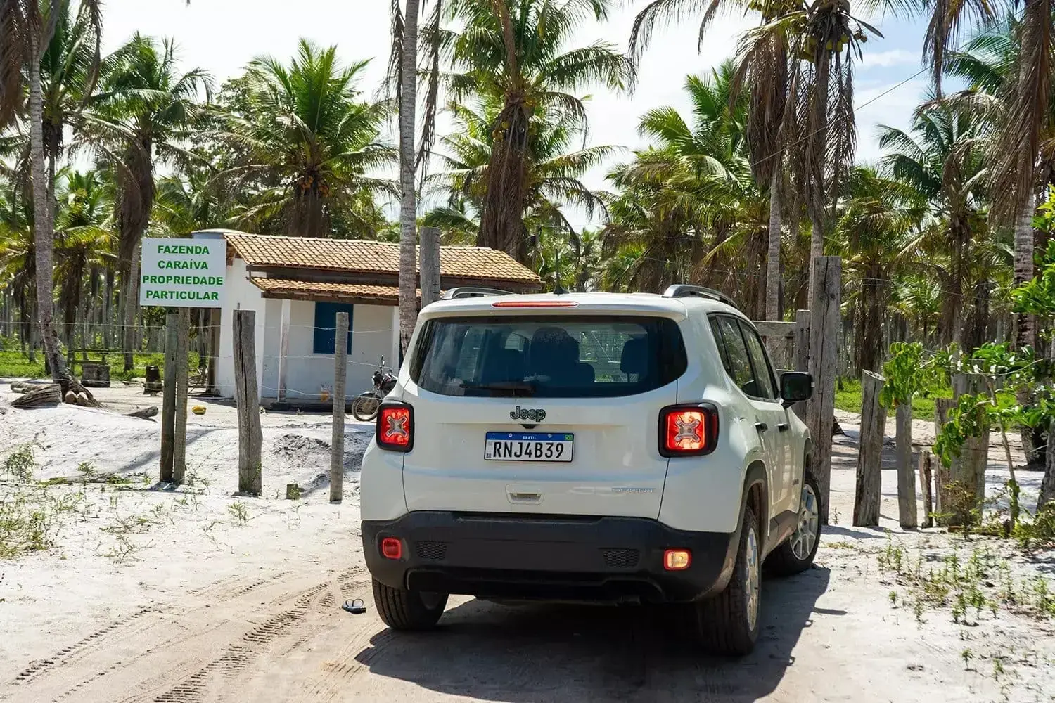 White 4x4 on a sand track among palm trees on the way to Satu beach