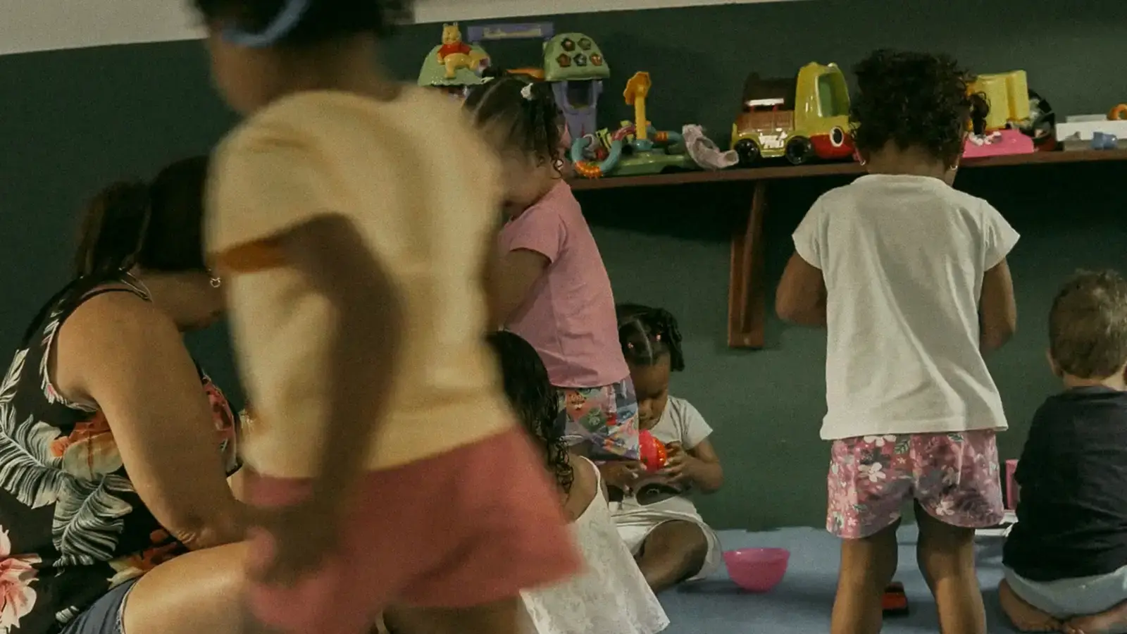 Crianças brincando no chão da sala da escola Filhos do Céu