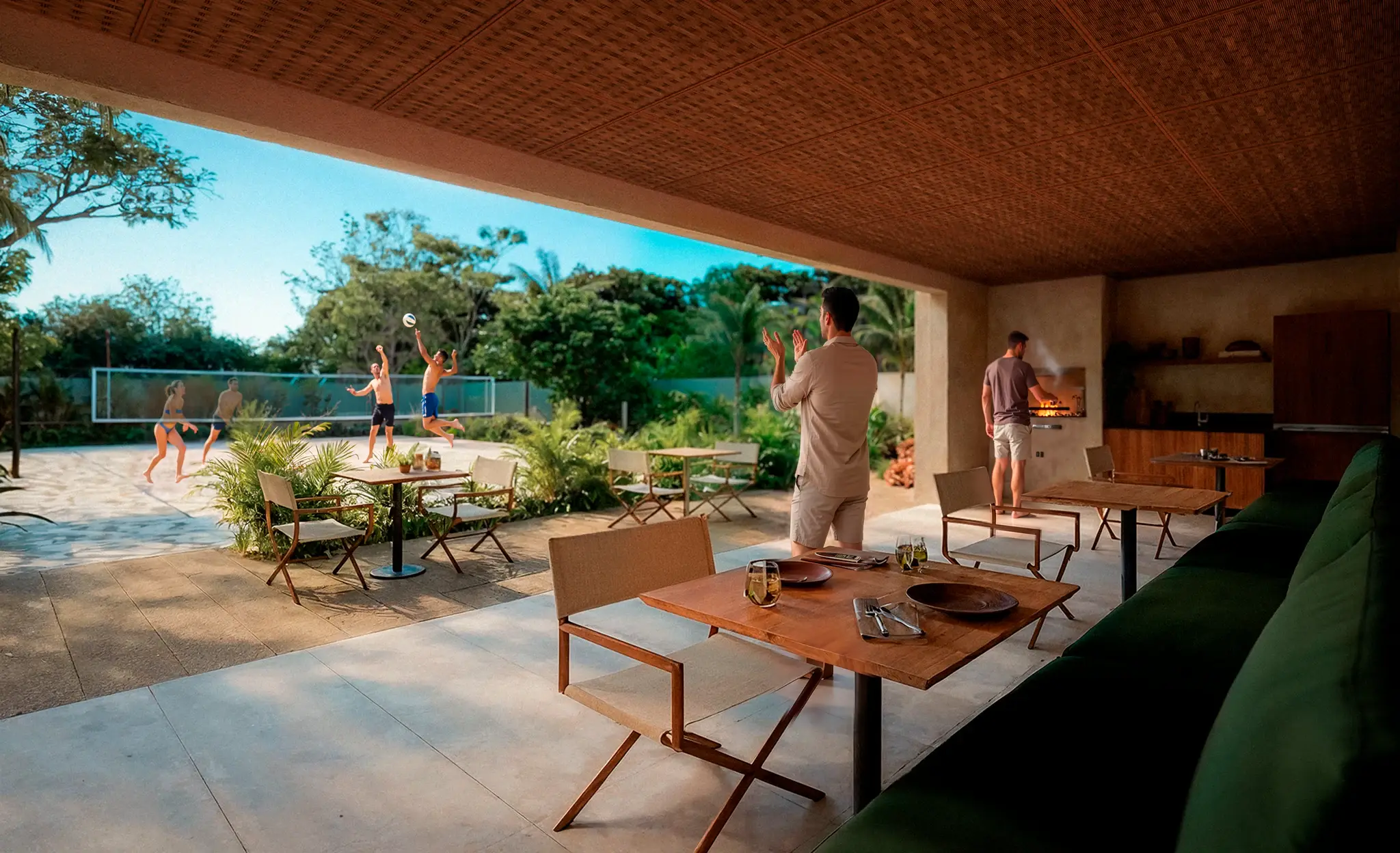 Covered dining area at VISTA, with wooden tables and a volleyball court beyond
