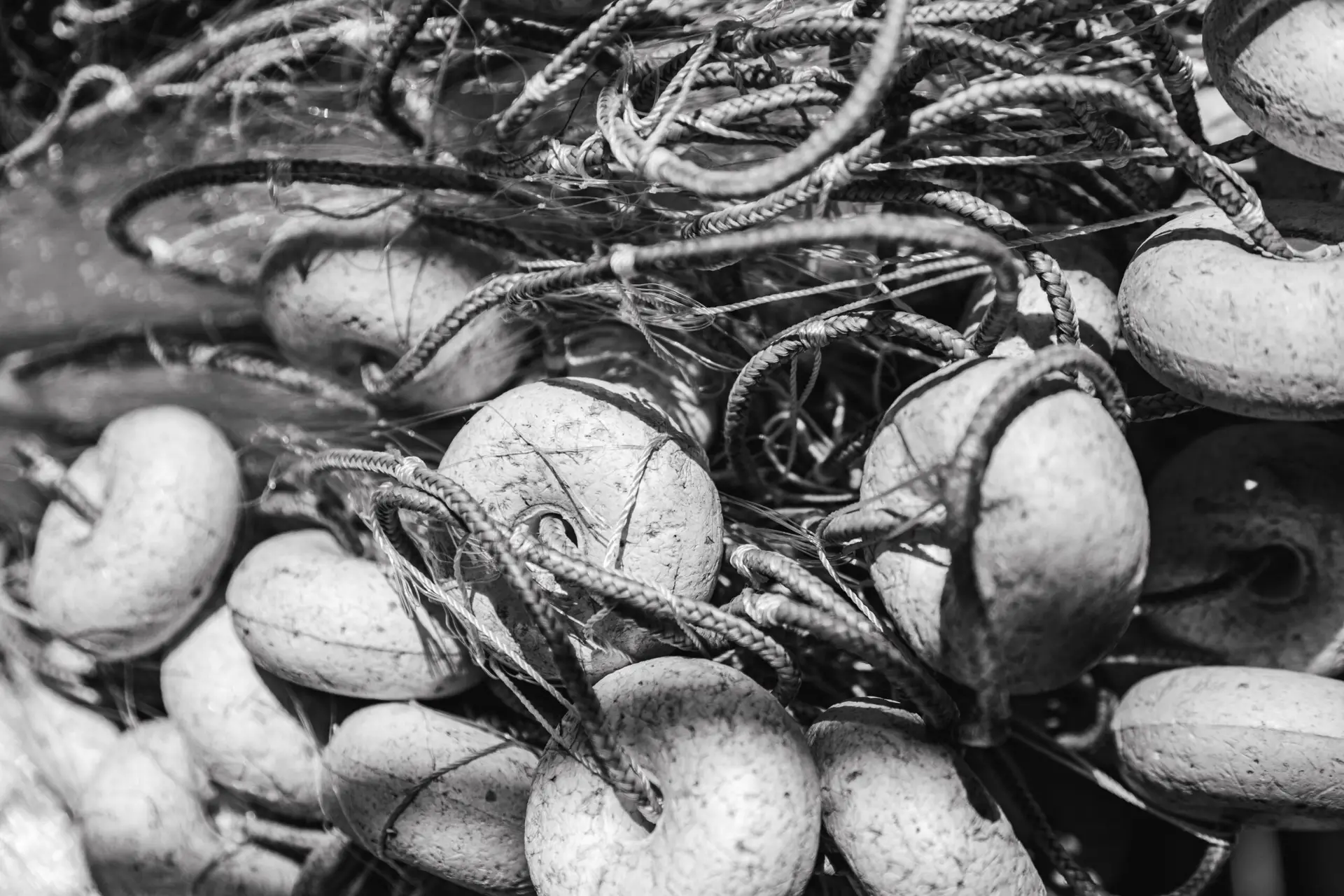 Casas de praia de alto padrão em Trancoso e Arraial d'Ajuda: uma imagem detalhada em preto e branco destaca redes de pesca, cordas e flutuadores complexos — elementos circulares entrelaçados, evocando o charme costeiro desses destinos litorâneos exclusivos.