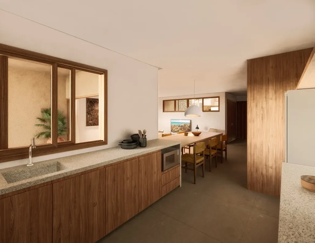 Casas de praia de alto padrão em Trancoso e Arraial d'Ajuda contam com cozinha moderna, armários de madeira, bancadas em pedra, pia embutida e micro-ondas. Janelas amplas sobre a pia iluminam o ambiente, enquanto na área ao fundo há mesa de jantar com cadeiras e uma paleta de cores neutras integra todo o espaço.